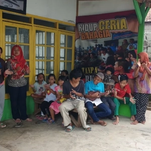 Children gather outside the shelter in Depok in West Java. The building offers a place of refuge [Jessica Washington/Al Jazeera]