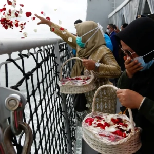 Family members pay their respects and scatter petals at the spot where Sriwijaya Air flight SJ182 crashed into the sea last month [File: Ajeng Dinar Ulfiana/Reuters]