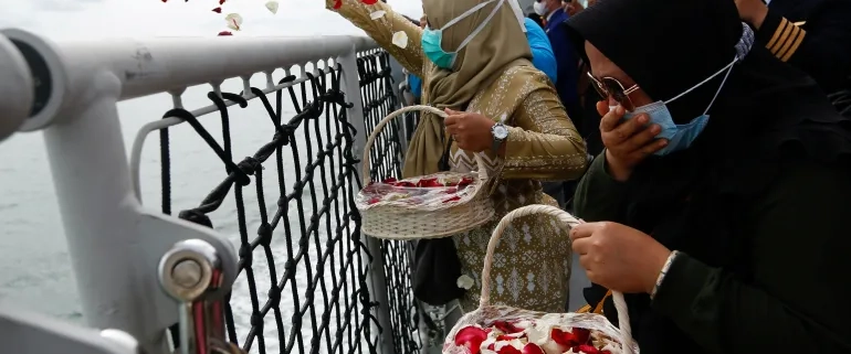 Family members pay their respects and scatter petals at the spot where Sriwijaya Air flight SJ182 crashed into the sea last month [File: Ajeng Dinar Ulfiana/Reuters]