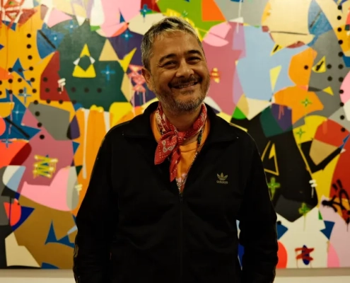 Cyril Kongo poses in front of one of his graffiti-style paintings at Art Jakarta [Jessica Washington/ Al Jazeera]