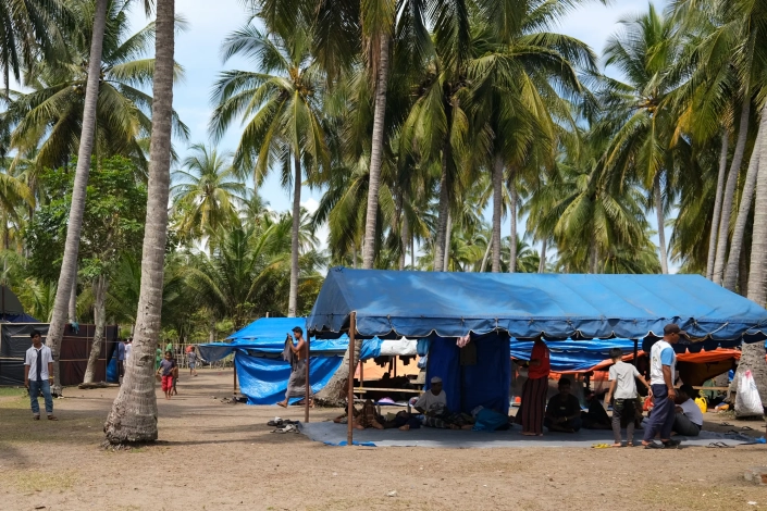 The refugees sleep under tarpaulins and coconut trees, with little to shield them from the heat and rain. [Jessica Washington /Al Jazeera]