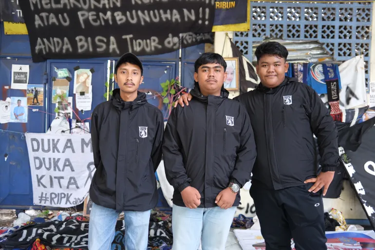 Galih Wahyu Prakoso with his friends Farel Izha Mahendra (left) and Cheva Octatista (right), who are members of a local football fan club. Three of their friends died on October 1, including 23-year-old Roni Setiawan, 18-year-old Muhammad Bintang Pratama Sekitar and 20-year-old Mayang Agustin [JHessica Washington/Al Jazeera]